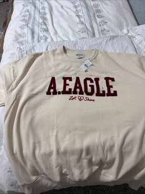 American Eagle Cream Sweatshirt with Burgundy Appliqué